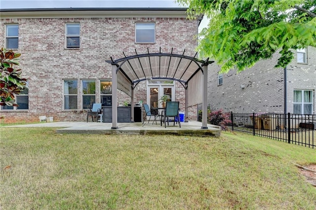rear view of property featuring a lawn, fence, and a patio area