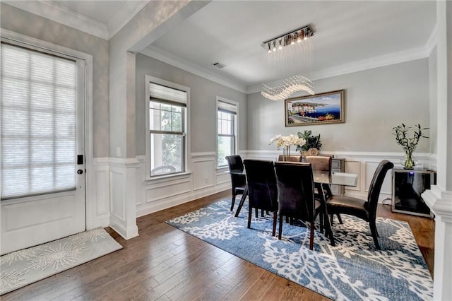 dining area featuring wainscoting, wood finished floors, and visible vents