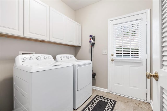 washroom featuring baseboards, cabinet space, and washing machine and clothes dryer