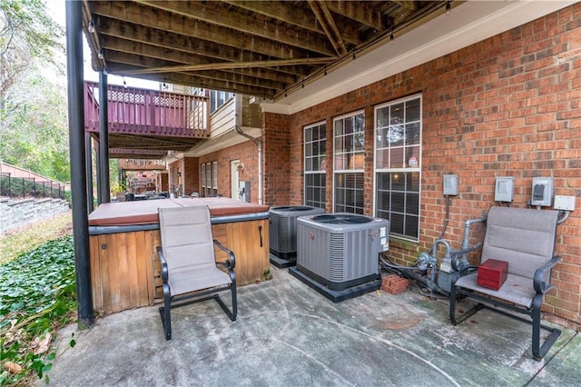 view of patio / terrace with central AC and a hot tub