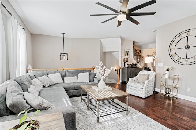 living room featuring ceiling fan, stairway, wood finished floors, and baseboards