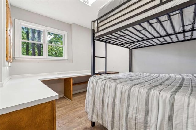 bedroom with baseboards and light wood-type flooring