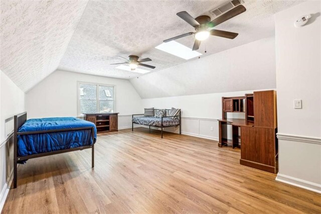 bedroom with visible vents, lofted ceiling, a textured ceiling, and wood finished floors