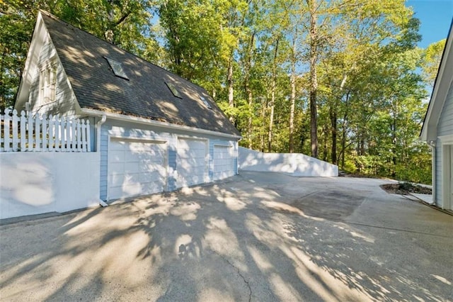 detached garage featuring fence