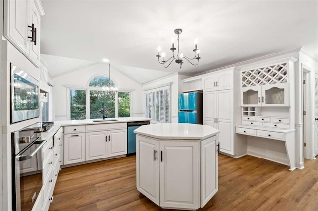 kitchen featuring a notable chandelier, a sink, a center island, stainless steel appliances, and light countertops