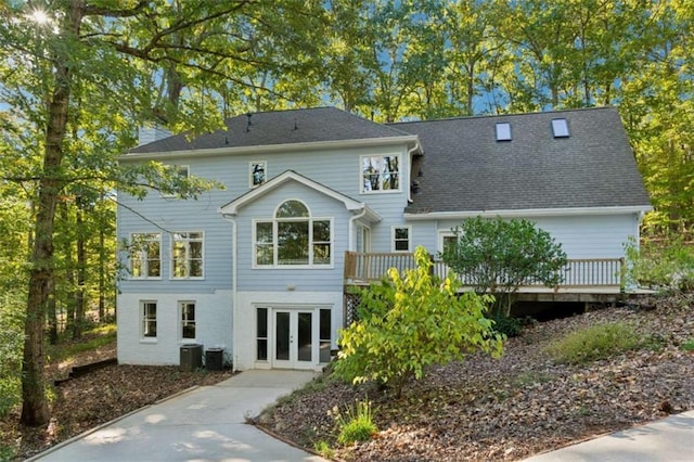 rear view of property featuring french doors, central AC unit, and a wooden deck