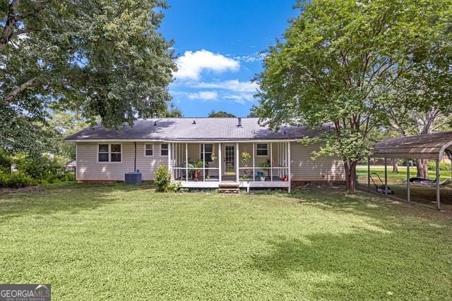 33 Russell Rd, Mcdonough, GA 30252 - rear view of house featuring a yard, a detached carport, and a sunroom