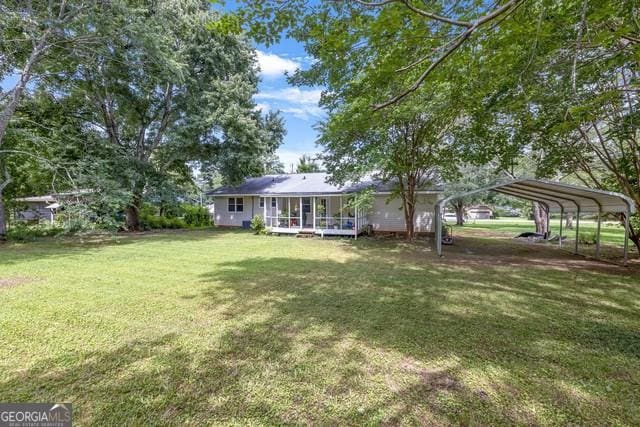 33 Russell Rd, Mcdonough, GA 30252 - view of grassy yard featuring a sunroom and a carport