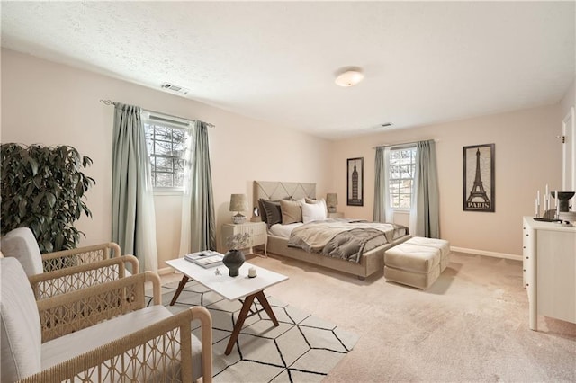 bedroom with light carpet, visible vents, and baseboards