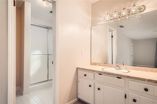 full bath featuring tile patterned flooring, vanity, visible vents, baseboards, and a stall shower