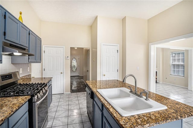 2928 Riverset Ct, Decatur, GA 30034 - kitchen with stainless steel gas range, under cabinet range hood, a kitchen island with sink, blue cabinetry, and a high ceiling