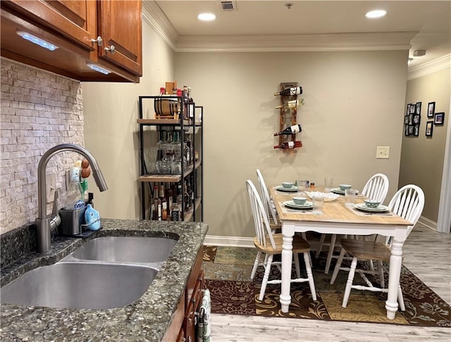 dining area featuring baseboards, ornamental molding, wood finished floors, and recessed lighting