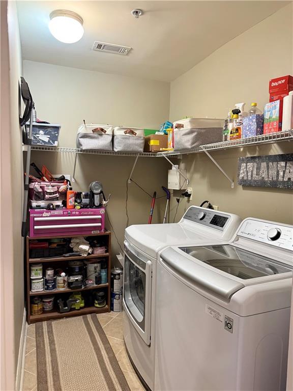 laundry area with separate washer and dryer, visible vents, laundry area, and light tile patterned floors