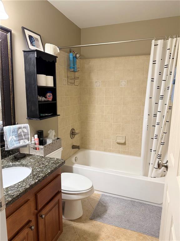 bathroom with shower / bath combination with curtain, tile patterned floors, vanity, and toilet