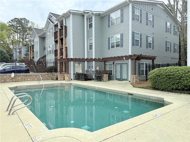 pool featuring a patio, fence, and french doors