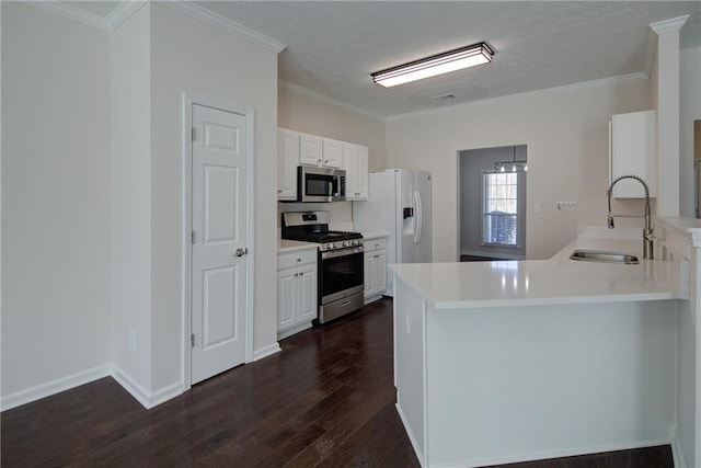 kitchen with stainless steel appliances, a peninsula, a sink, white cabinets, and dark wood finished floors