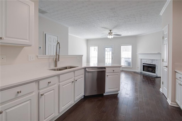 kitchen featuring dark wood finished floors, dishwasher, a premium fireplace, crown molding, and a sink