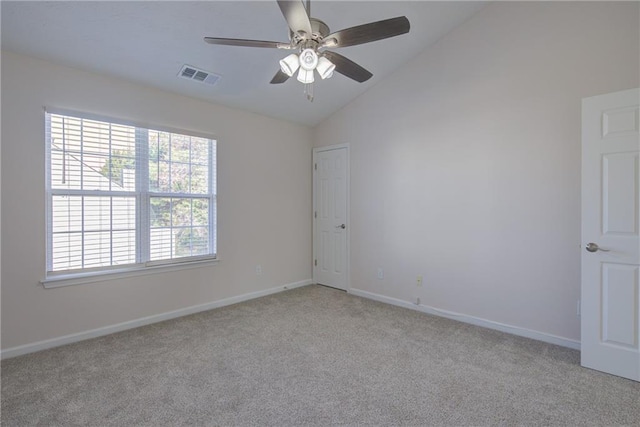 empty room with light colored carpet, lofted ceiling, visible vents, and baseboards