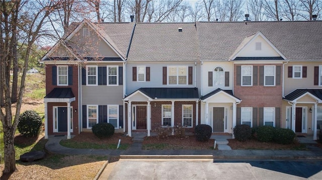 multi unit property featuring metal roof, brick siding, and a standing seam roof