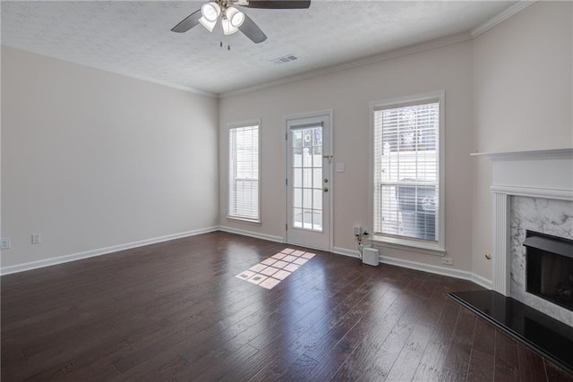 unfurnished living room featuring a textured ceiling, visible vents, a high end fireplace, baseboards, and dark wood finished floors