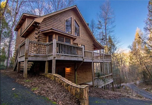 rear view of property featuring a wooden deck