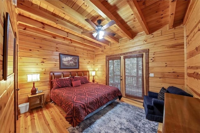 bedroom with beamed ceiling, light hardwood / wood-style flooring, wood walls, ceiling fan, and wooden ceiling