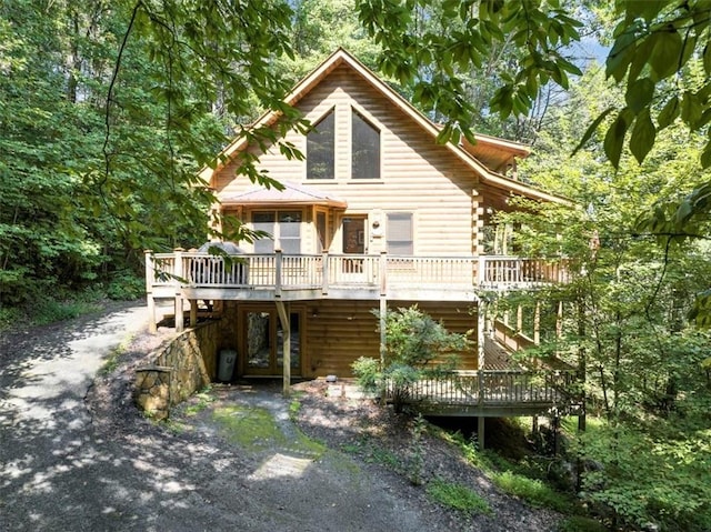 rear view of house featuring a wooden deck