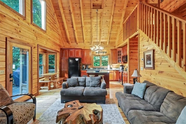 living room with wooden walls, wood ceiling, light hardwood / wood-style floors, a notable chandelier, and high vaulted ceiling