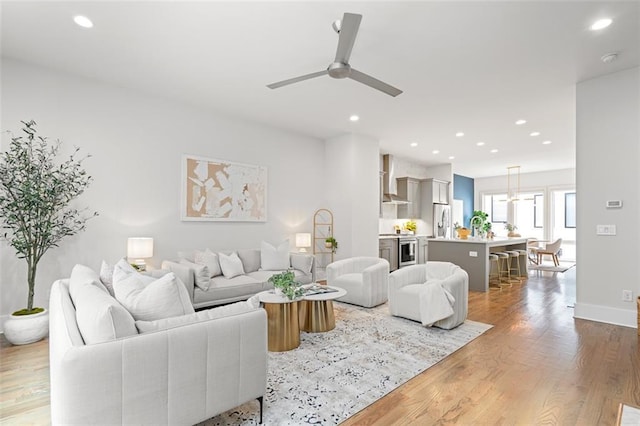 living room featuring ceiling fan and light wood-type flooring