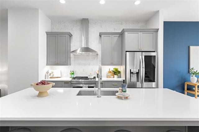 kitchen featuring sink, gray cabinets, wall chimney exhaust hood, and appliances with stainless steel finishes