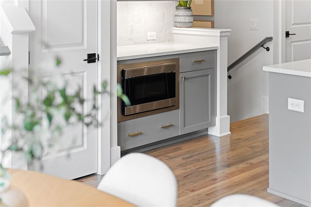 interior space with decorative backsplash and wood-type flooring