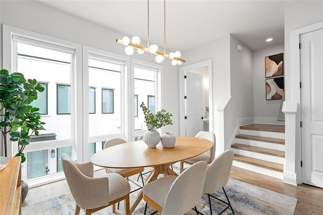 dining area featuring an inviting chandelier, plenty of natural light, and wood-type flooring