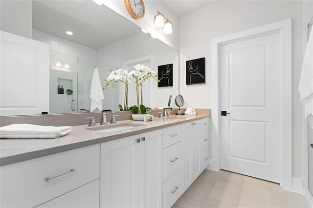 bathroom featuring a shower with door, vanity, and tile patterned flooring