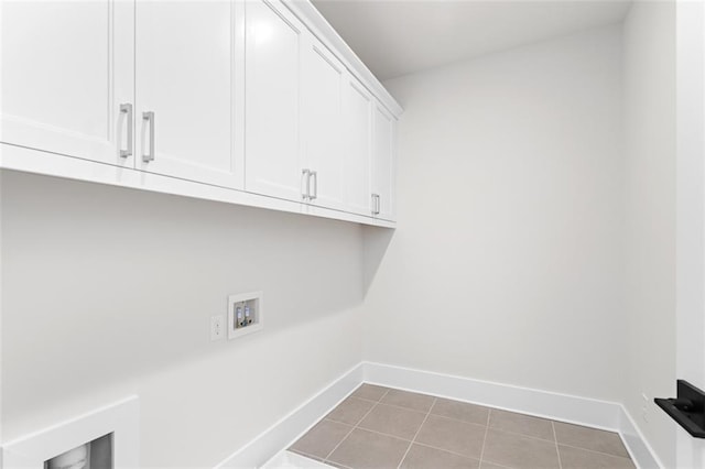 clothes washing area with cabinets, washer hookup, and tile patterned floors