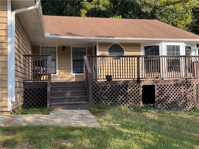 back of house featuring a deck and a lawn