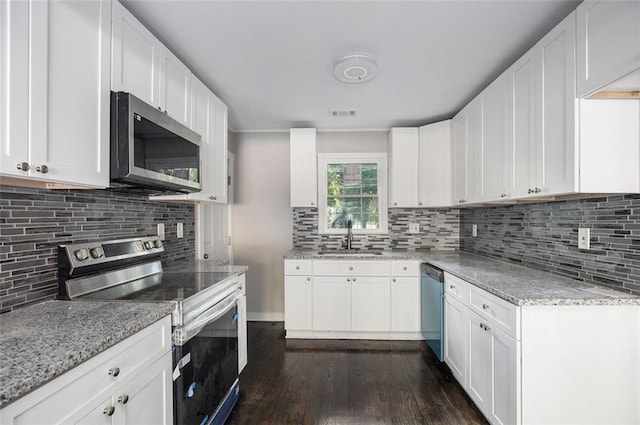 3060 Washington Rd, Atlanta, GA 30344 - kitchen featuring appliances with stainless steel finishes, a sink, dark wood-style flooring, light stone countertops, and tasteful backsplash