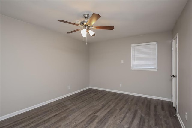 empty room with dark wood-style floors, baseboards, and a ceiling fan