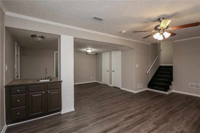 basement featuring stairs, visible vents, dark wood-type flooring, and a sink