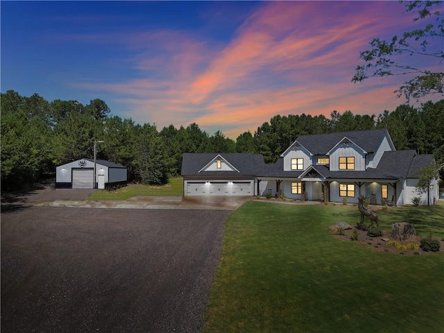 modern farmhouse style home featuring a garage and a lawn