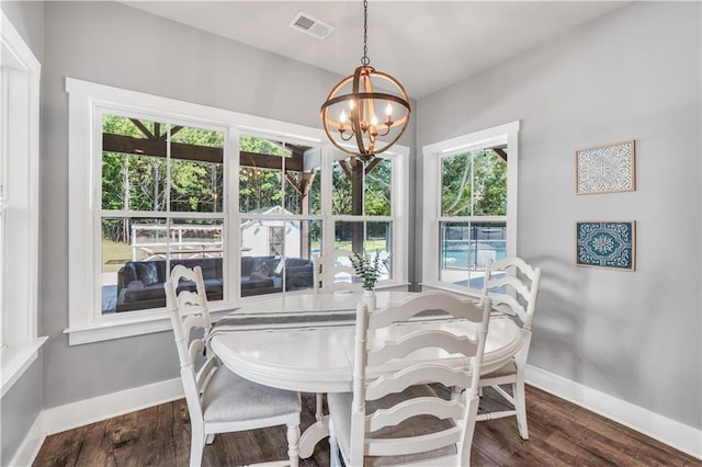 dining area featuring dark wood-type flooring, a chandelier, and a healthy amount of sunlight