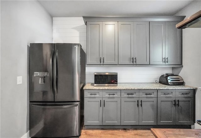 kitchen featuring gray cabinetry, stainless steel appliances, and light wood-type flooring