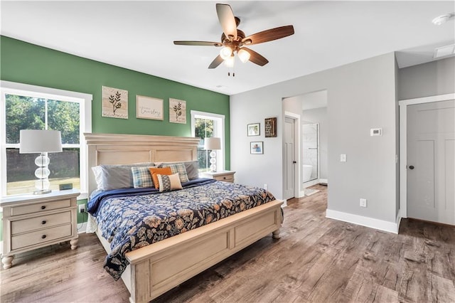 bedroom with ceiling fan, wood-type flooring, and multiple windows