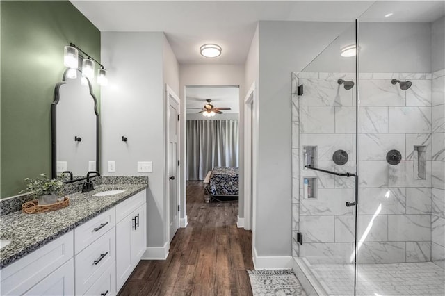 bathroom with hardwood / wood-style flooring, ceiling fan, vanity, and a shower with shower door