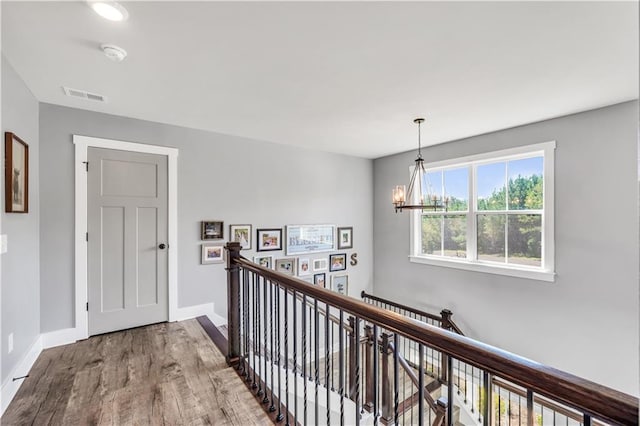 hall with a chandelier and hardwood / wood-style floors