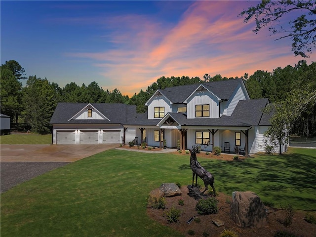 modern inspired farmhouse with a porch, a garage, and a lawn