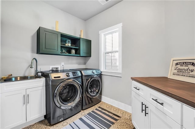 washroom featuring cabinets, sink, and washer and clothes dryer