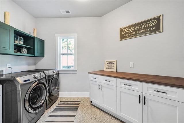 washroom featuring washer and clothes dryer and cabinets