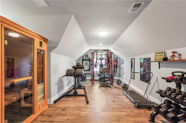 exercise area with vaulted ceiling and light wood-type flooring