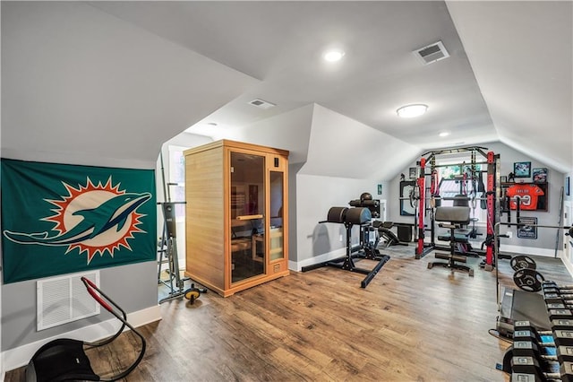 workout room featuring lofted ceiling and hardwood / wood-style floors