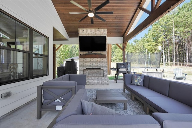 view of patio with an outdoor living space with a fireplace and ceiling fan